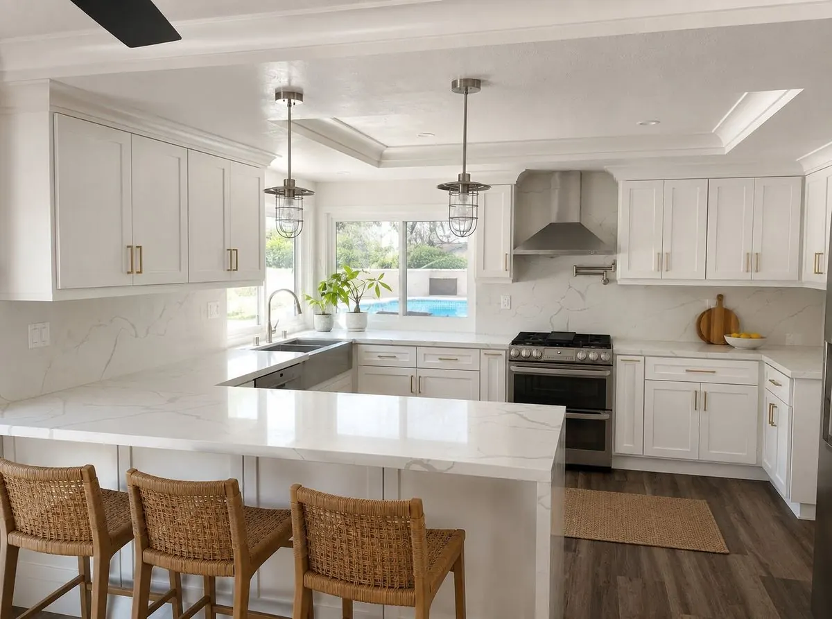 Completed white-and-brass kitchen with quartz peninsula, rattan stools and pool view in Diamond Bar, CA by Serrano Construction